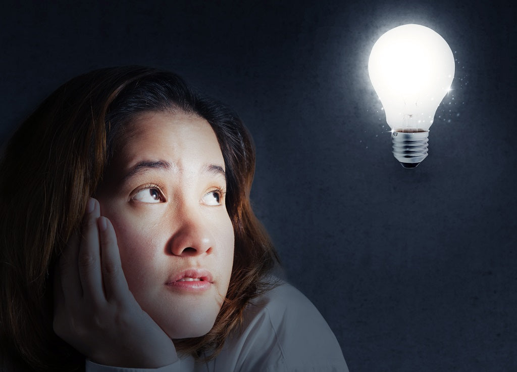 Young woman looking at a light bulb